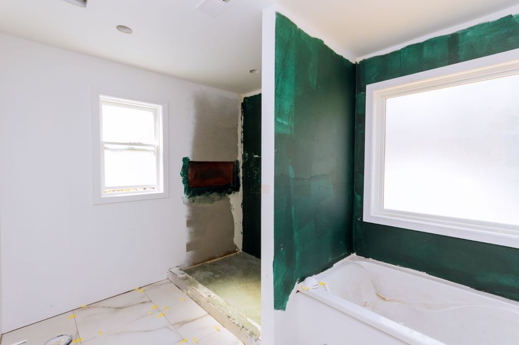 Unfinished apartment bathroom showing drywall repair and interior finishing work in progress