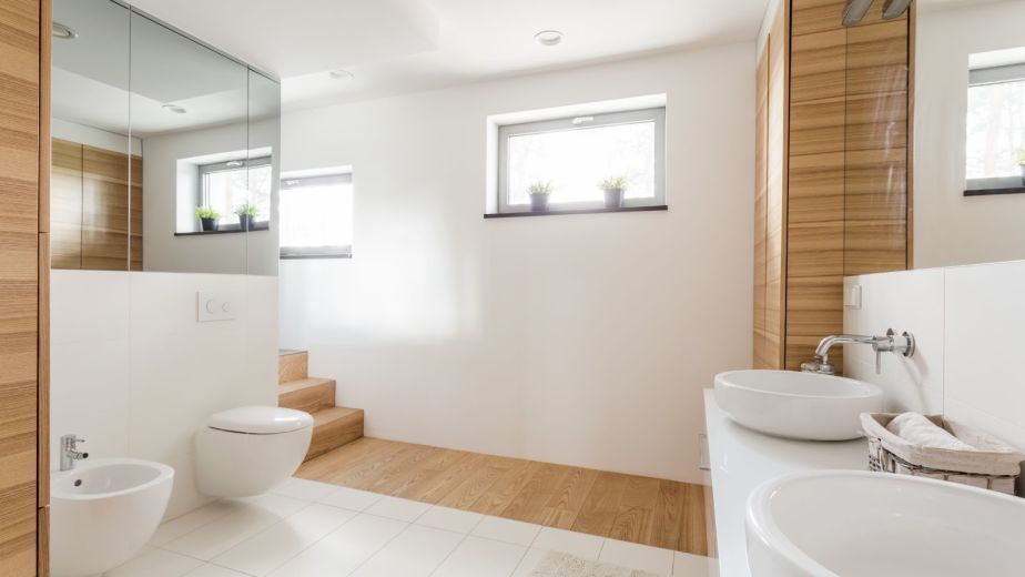 New second-floor bathroom addition with toilet and expansive mirrors