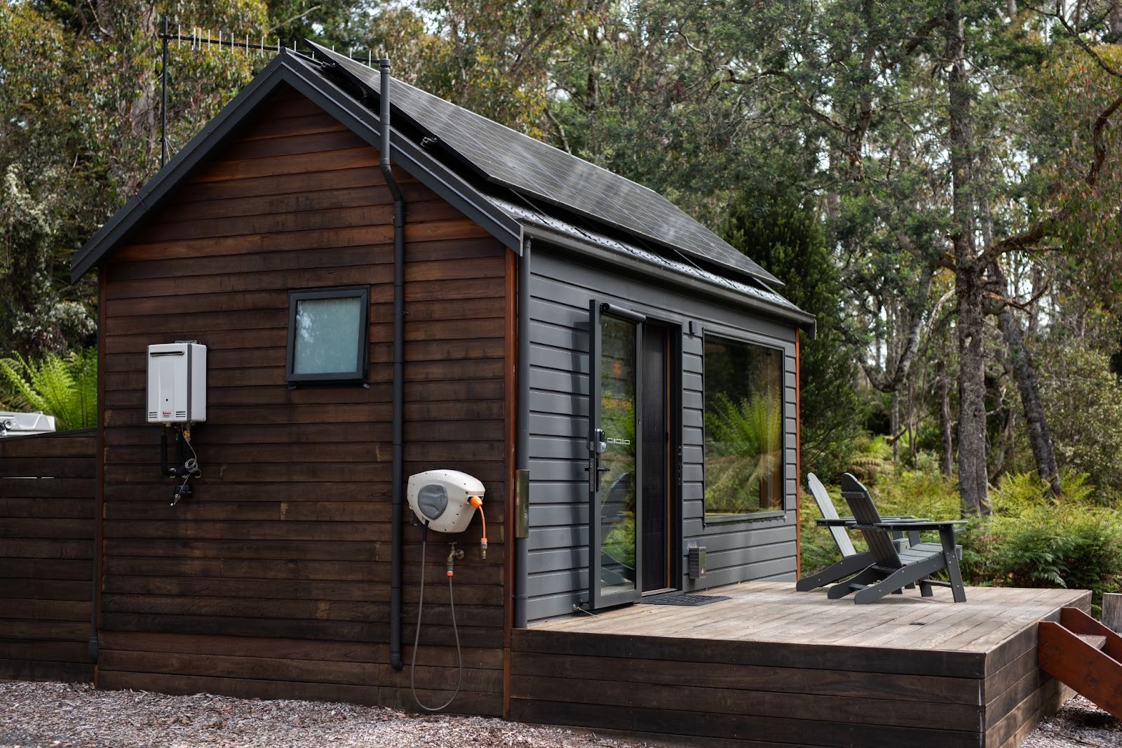 A detached accessory dwelling unit built as a small cabin in a spacious residential backyard