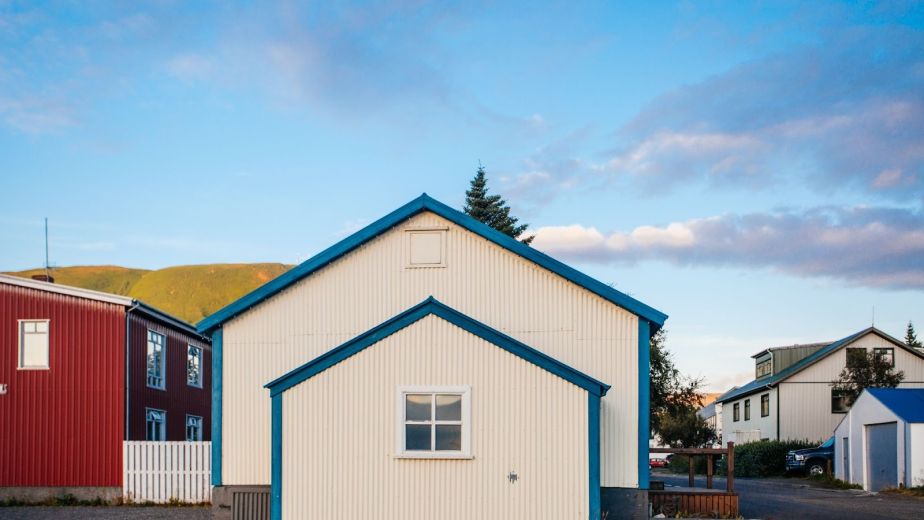 Modern white house with a front-facing garage-type accessory dwelling unit highlighted by blue trim