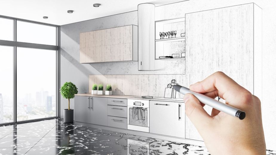 Designer sketching a loft-style kitchen interior with cabinetry, furniture, and natural light