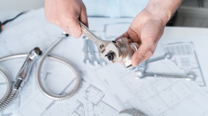 Plumber reviewing plumbing plan while trying a pipe tee fitting in the water supply system