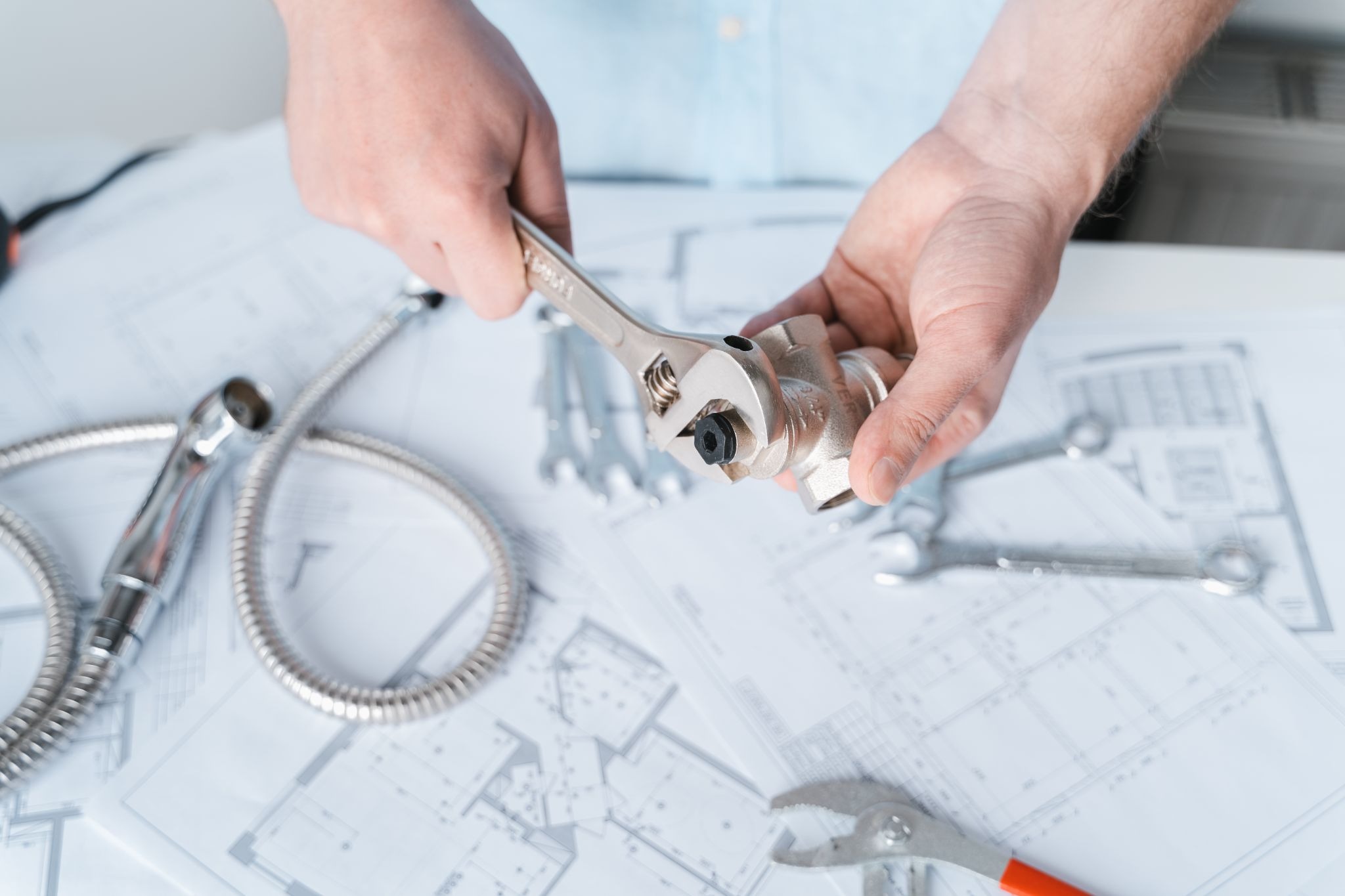 Plumber reviewing plumbing plan while trying a pipe tee fitting in the water supply system