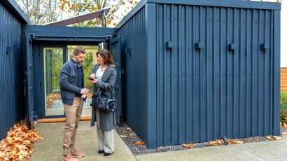 Homeowners discussing ADU design plans outside a modern residential property